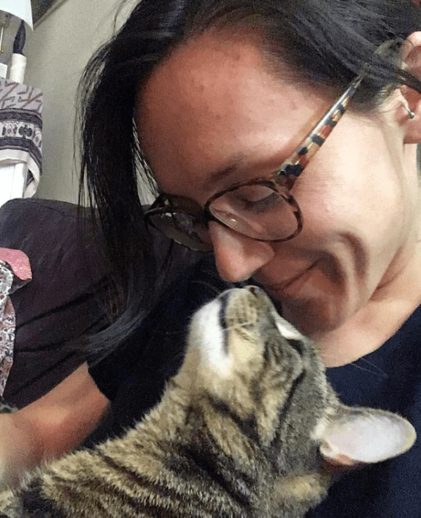 cat touching noses with human